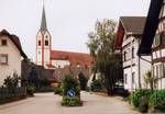 Bachallee mit Blick auf die Kirche, grüne Straßeninseln sind zu sehen